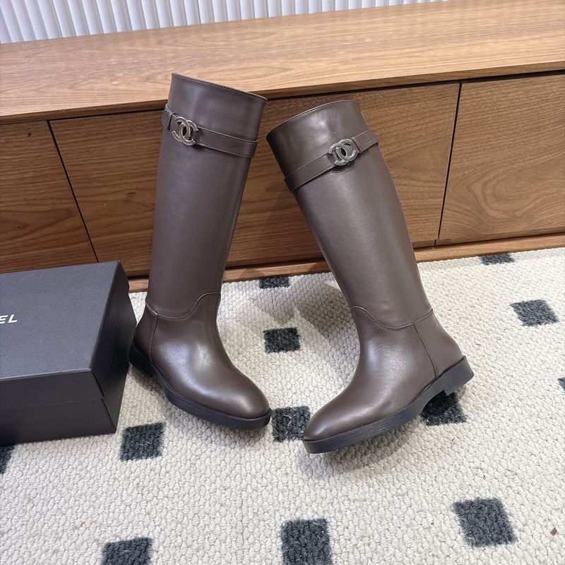 Chanel CC logo knee-high riding boots in dark taupe calfskin leather with silver hardware buckle strap, displayed with original Chanel box